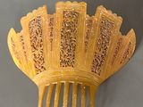 a yellow hair comb that is shaped like a fan