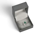 a close up of a ring in a box on a white surface