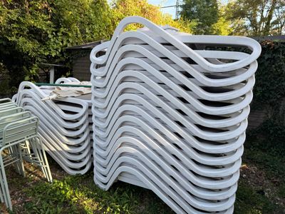 a lot of chairs that are stacked up in the grass
