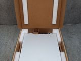 une boîte ouverte contenant un ordinateur portable, posée sur une surface grise