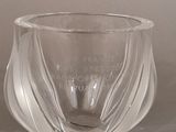 un vase en verre orné d'une citation, posé sur une table