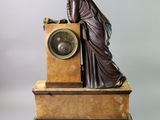 statue of a woman leaning on a clock on a marble base