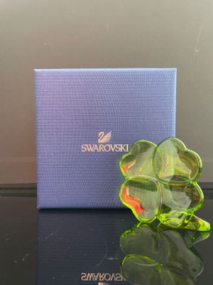 une fleur en verre vert posée sur une table, à côté d'une boîte bleue