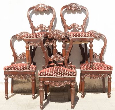 four antique chairs with red upholstered seats are sitting against a white wall