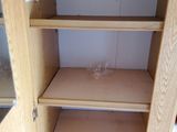 a wooden cabinet with shelves in the corner of the room