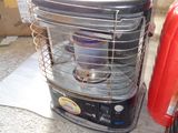une valise rouge posée par terre à côté d'un radiateur d'appoint