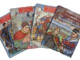 quatre livres pour enfants sont alignés sur une surface blanche
