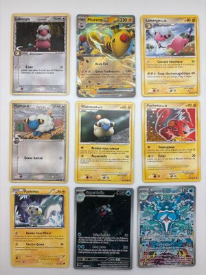 Des cartes Pokémon sont alignées sur une surface blanche