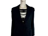 Le mannequin porte un blazer noir et un haut rayé.