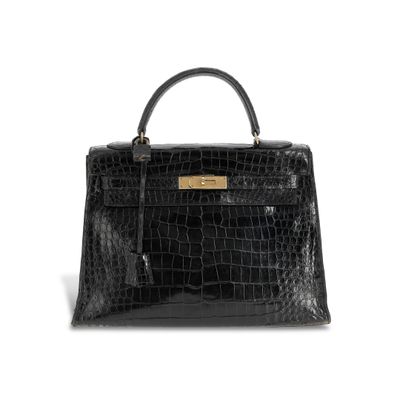 a black crocodile skin handbag on a white background