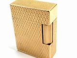 an image of a gold lighter sitting on top of a white surface
