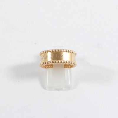 gros plan d'une bague en or sur une surface blanche