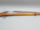 a rifle with a wooden barrel on a white surface