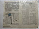 an old newspaper with a stamp on it sitting on top of a table