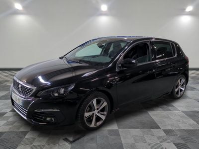 La voiture noire est garée sur un sol carrelé à damier.