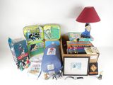 a table with a lamp, books, tins, and other items on it