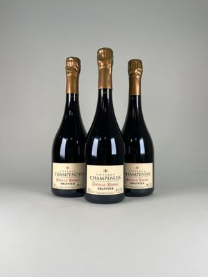trois bouteilles de champagne posées côte à côte sur une table