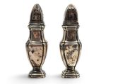 a pair of silver salt and pepper shakers on a white background