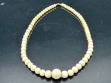 gros plan d'un collier de perles sur une surface noire