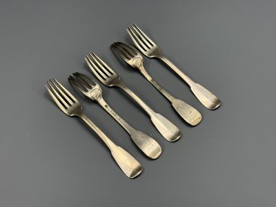 un service de quatre fourchettes et un couteau posés sur une table