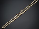 un collier de perles avec un fermoir en or sur fond noir