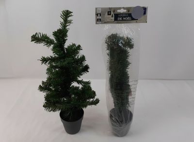 a small christmas tree in a plastic bag next to a small potted christmas tree