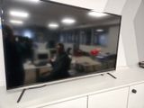 une télévision à écran plat posée sur un meuble TV blanc