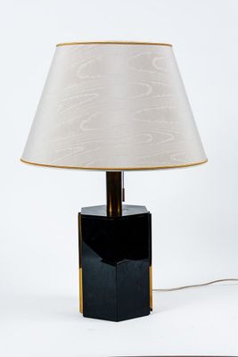 une lampe de table noire surmontée d'un abat-jour blanc