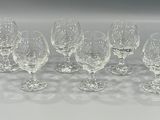 six empty wine glasses are lined up on a white surface