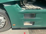 a green semi truck parked in a parking lot