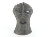 a black vase with a face on it on a white surface