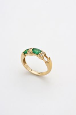 a gold ring with emerald stones and diamonds