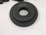 four black plastic parts are sitting on a white surface