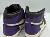 a pair of purple and black sneakers on a white surface