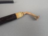 a pipe that is sitting on a table next to a pen