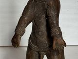 une petite statue représentant un ours coiffé d'un chapeau