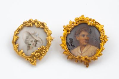 two miniature portraits of a man and a woman in gold frames