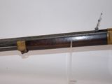 a close up of a rifle on display on a white surface