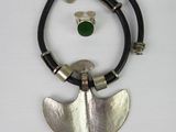 silver and green necklace with leather cord and a silver pendant with a green glass bead