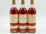 trois bouteilles de vin posées les unes à côté des autres sur une surface blanche