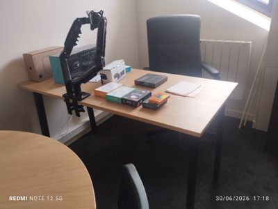 un bureau sur lequel se trouvent un écran d'ordinateur et un téléphone portable