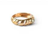 a close up of a gold ring on a white surface