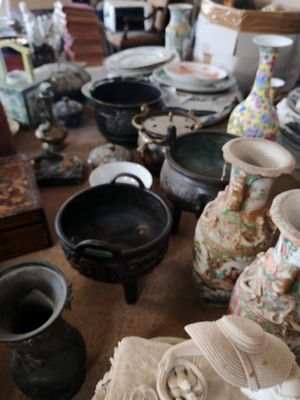 de nombreux vases et bols de toutes sortes sur la table