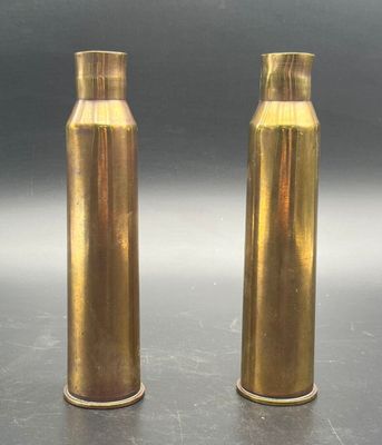 two gold vases on a table with a black background