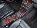 the interior of a car with black leather seats and wood trims