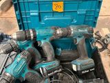 une boîte à outils bleue remplie d'outils électriques, posée par terre