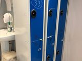 a blue locker in a bathroom with a sink and a toilet