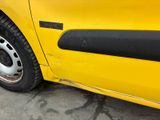 a close up of a yellow car parked in a parking lot