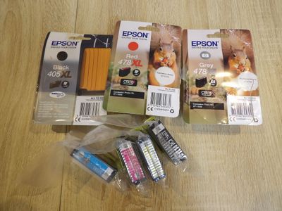 Plusieurs cartouches d'encre sont posées les unes à côté des autres sur une table