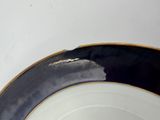 a black and white plate with gold trim on it